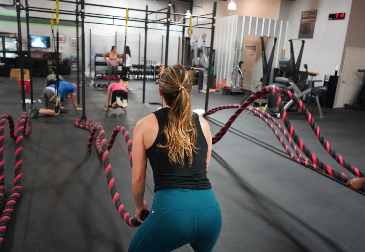 woman in the gym using battle ropes